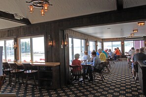 A restaurant with wooden walls, large windows, and a patterned floor.
