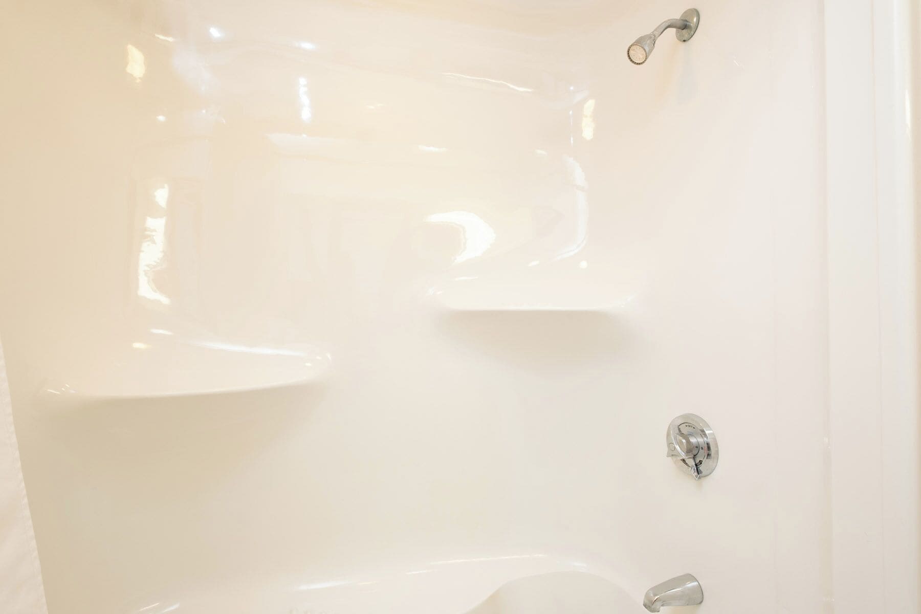 A bathroom with a white bathtub, a shower, and a toilet.