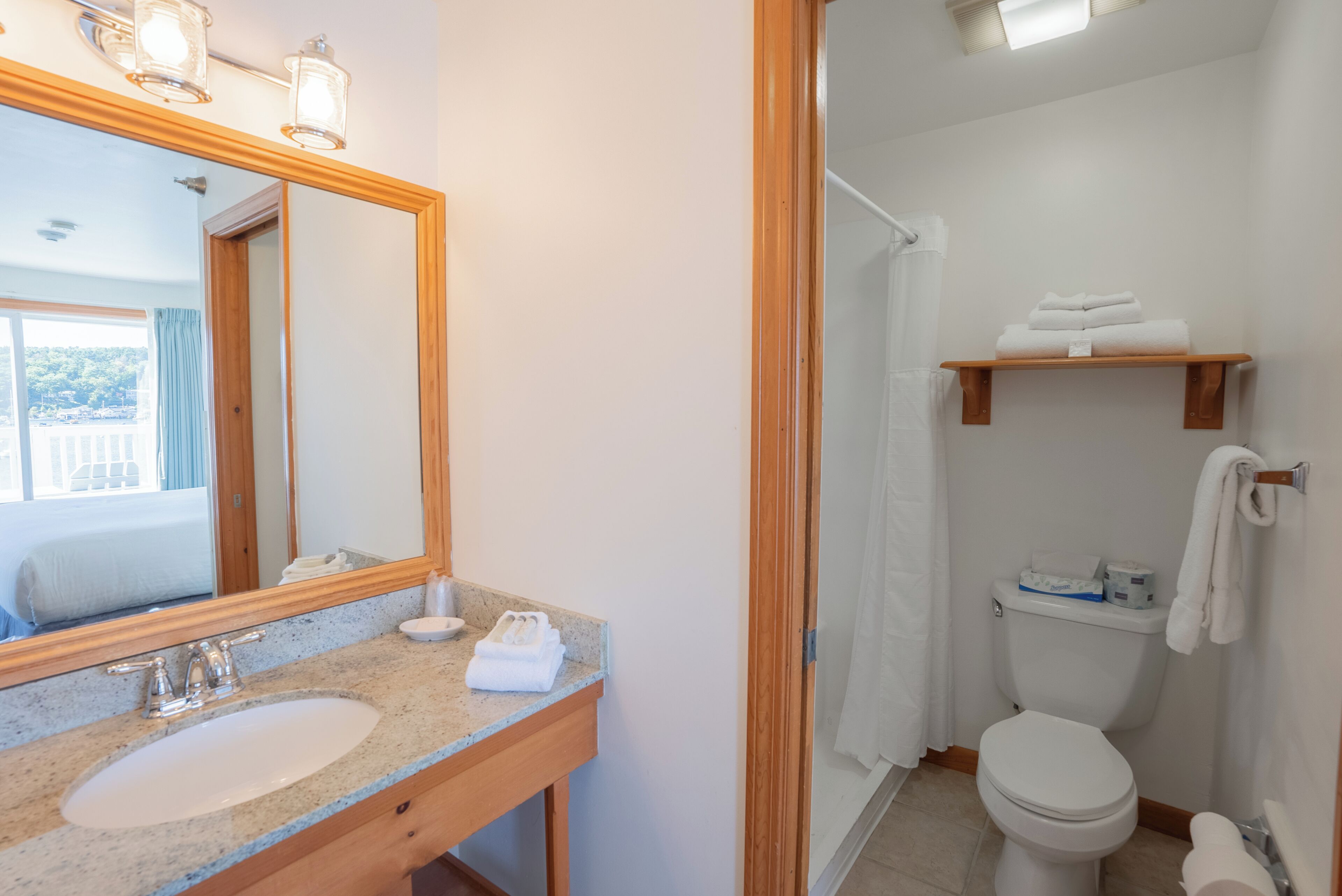 A bathroom with a sink, mirror, and toilet.
