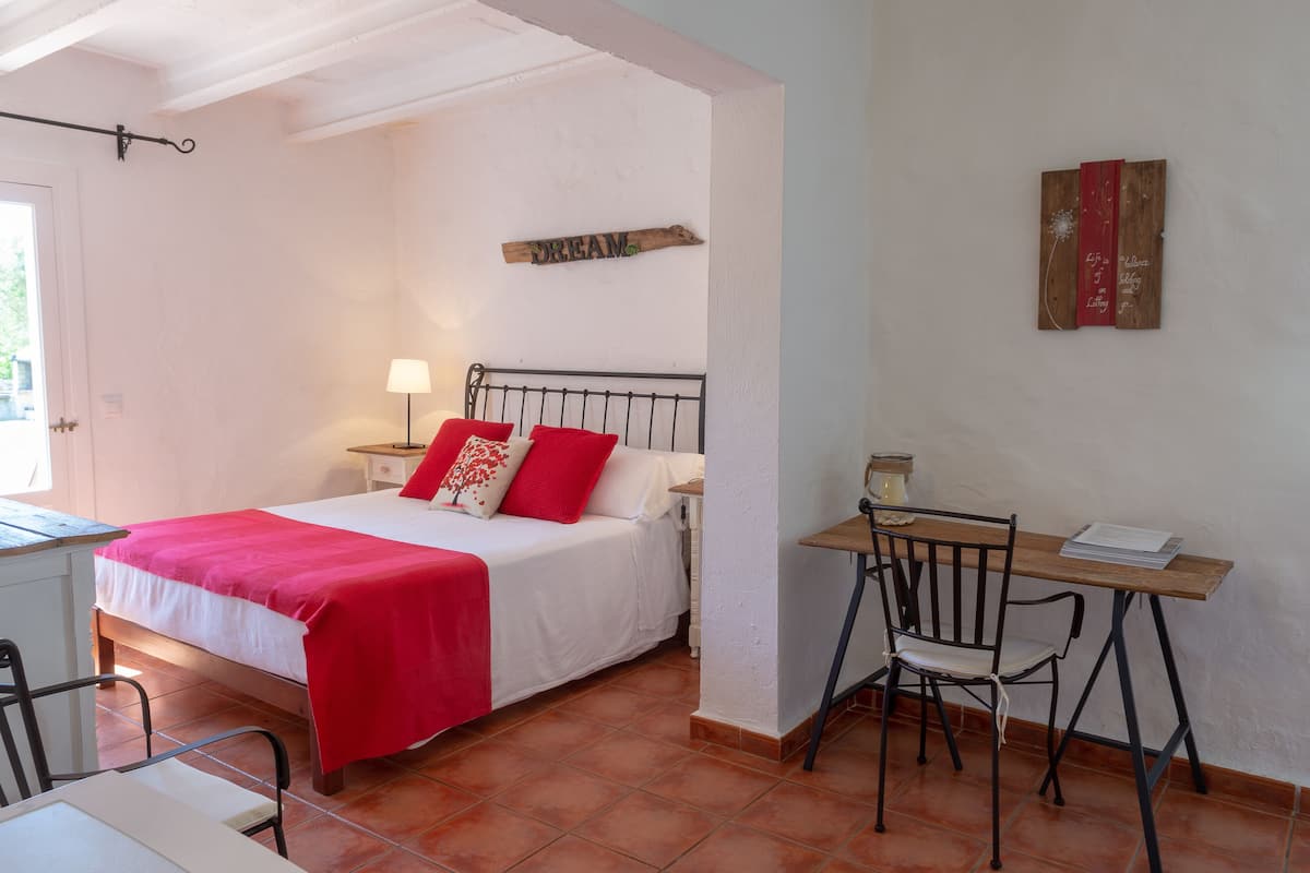 A bedroom with a bed, a desk, and a chair.