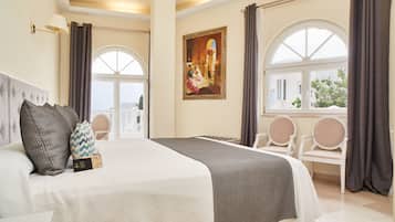 A hotel room with a large bed, a painting on the wall, and a view of the outside through a window.