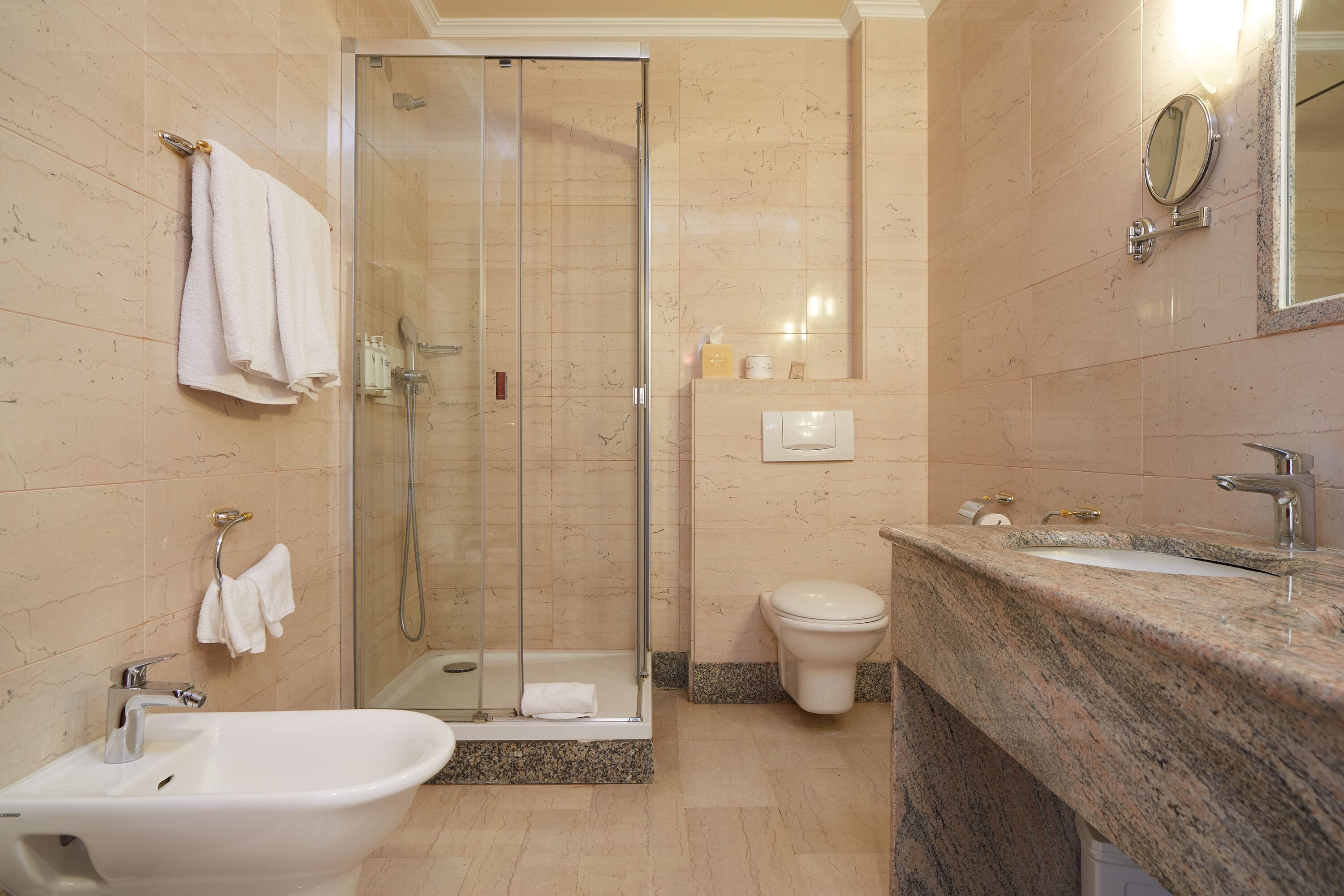 Un baño con ducha de mampara, lavabo e inodoro.
