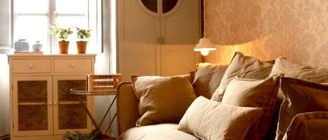 A cozy room with a sofa, a cabinet with glass doors, and a lamp.