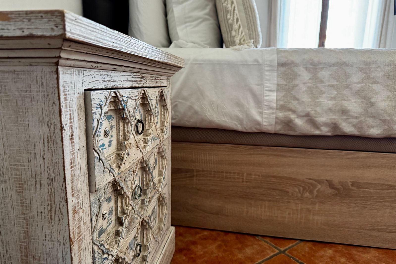 A rustic wooden dresser with a distressed finish and decorative metal accents.