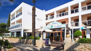 A multi-story hotel with a sign for 'Des Figuiers Cafe & Cocktails'. - Hotel Ses Figueres (Ibiza Town)