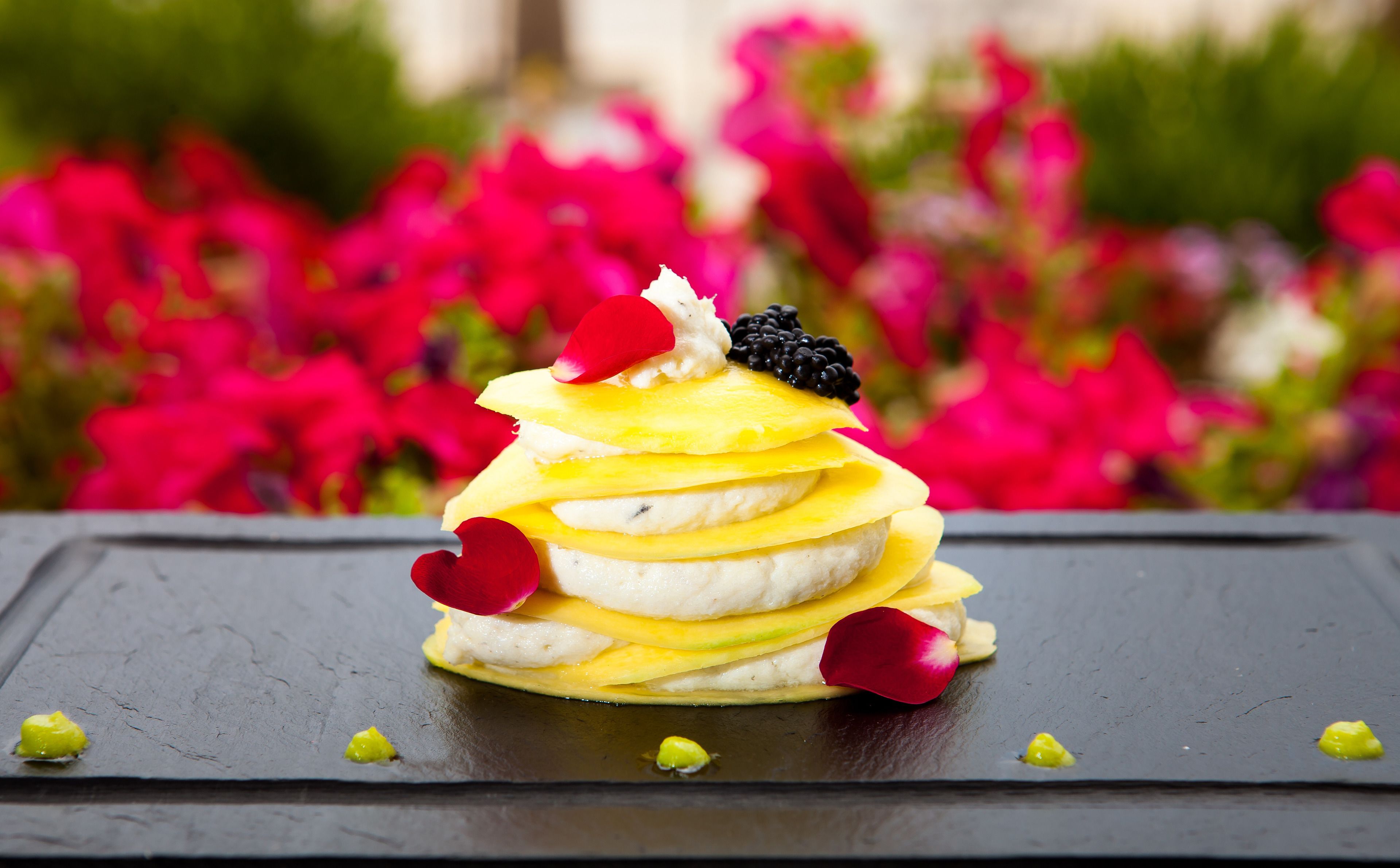 Dessert op een leisteenbord, met een vage achtergrond van bloemen.