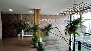 A spacious lobby with a staircase, potted plants, and a sign reading "CARDONA". - Hostal Residencia Cardona (Arrecife)