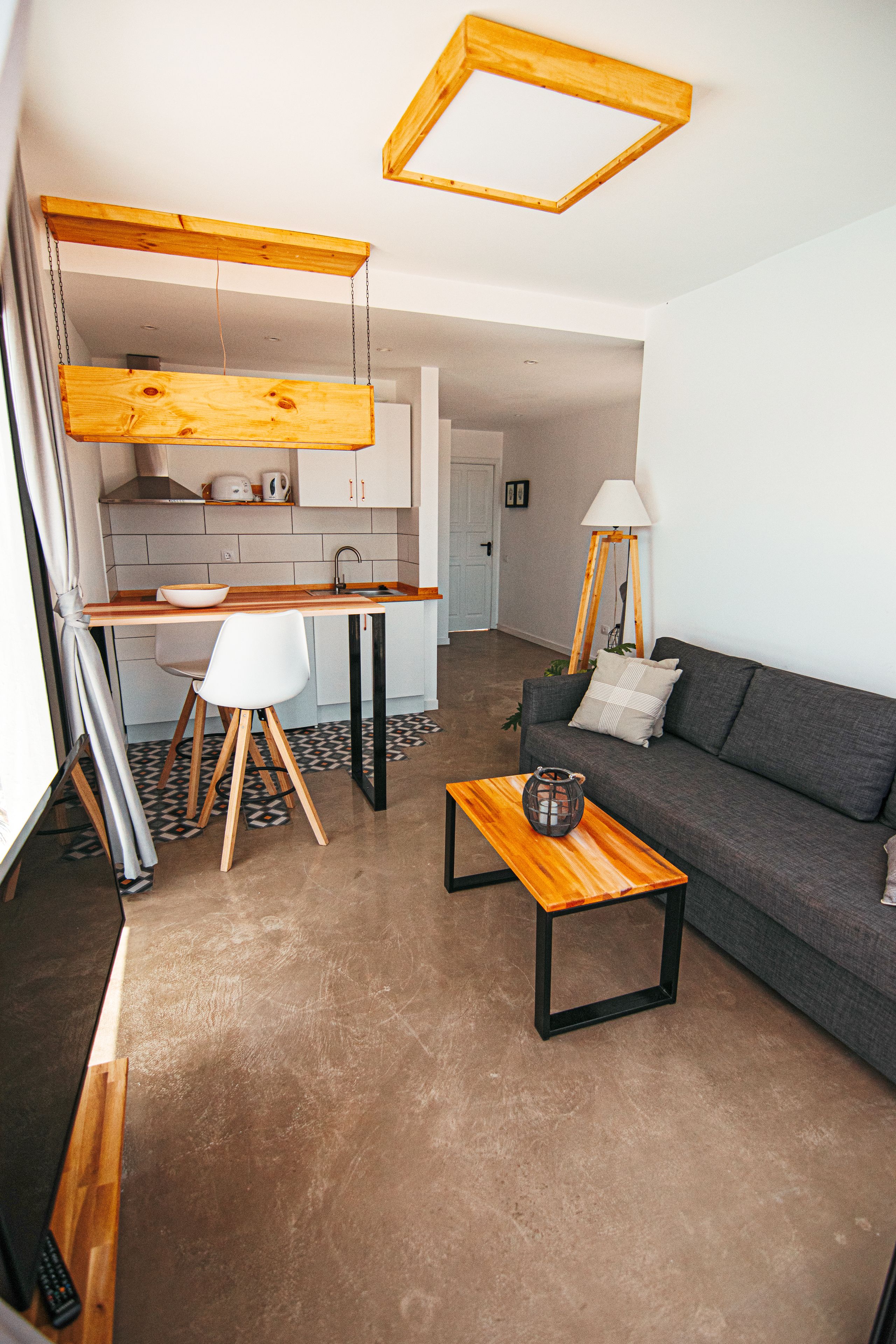 A compact living space with a kitchenette, a dining area, and a seating area with a sofa and coffee table.