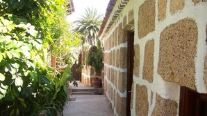 A narrow stone pathway leading to a building with a rustic exterior. - Casa Rural Anton Piche (Granadilla de Abona)