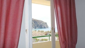 Una habitación con vista a un litoral rocoso y un acantilado.
