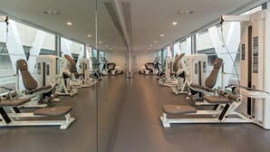 A gym with mirrored walls, multiple exercise machines, and large windows. - Santa Mónica Suites Hotel (San Bartolome de Tirajana)