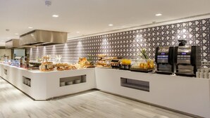 A modern breakfast bar with a patterned backsplash, a coffee machine, and a variety of breakfast items. - Santa Mónica Suites Hotel (San Bartolome de Tirajana)