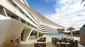 A modern hotel with a pool area, outdoor seating, and a unique architectural design. - Santa Mónica Suites Hotel (San Bartolome de Tirajana)