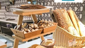 A variety of baked goods displayed on tables and baskets, including bread, pastries, and cookies. - Santa Mónica Suites Hotel (San Bartolome de Tirajana)