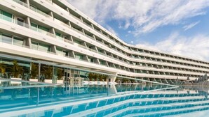A modern hotel with a curved facade and a large pool area. - Santa Mónica Suites Hotel (San Bartolome de Tirajana)