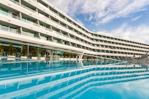 A modern hotel with a curved facade and a large pool area. - Santa Mónica Suites Hotel (San Bartolome de Tirajana)