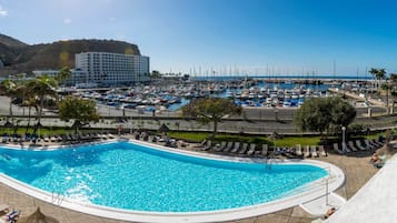 Een buitenzwembad, parasols voor strand/zwembad