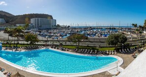 Una piscina al aire libre, sombrillas, tumbonas
