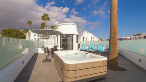 A rooftop pool area with a hot tub, lounge chairs, and palm trees. - Rosamar Resort Lanzarote (Tías)