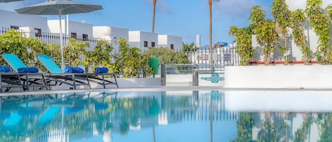 Piscine extérieure, parasols de plage, chaises longues