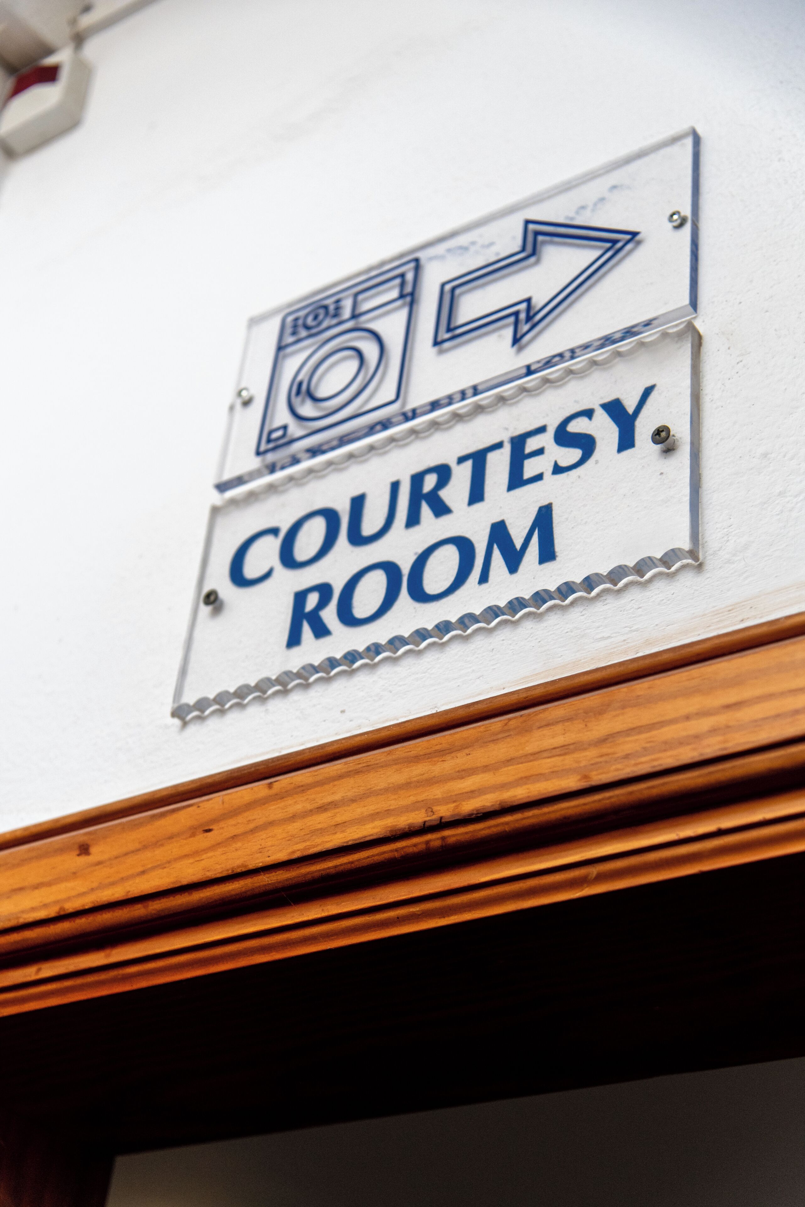 A sign indicating a courtesy room with directional arrows.