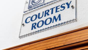 A sign indicating a courtesy room with directional arrows.