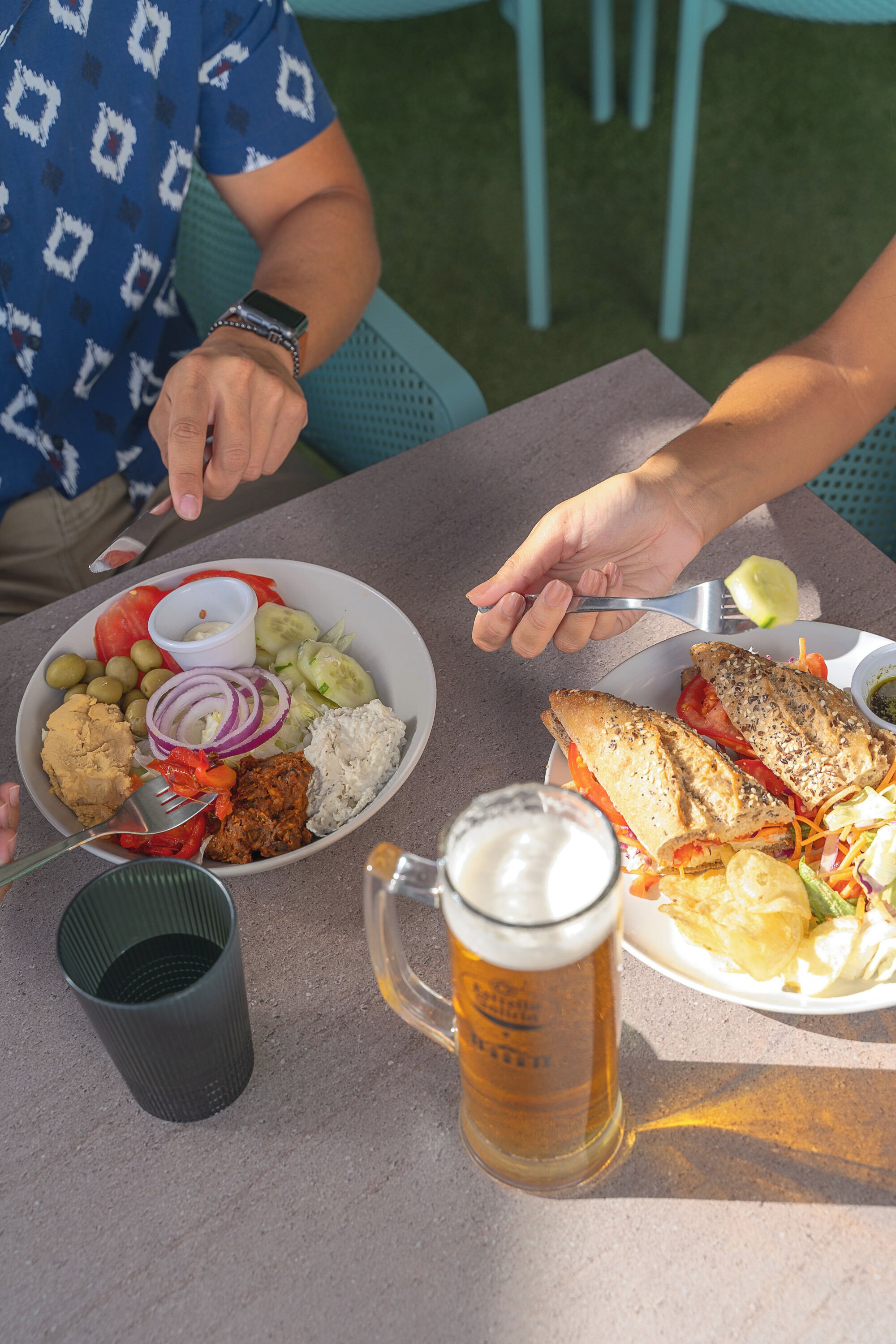 A meal with a variety of dishes and a beer mug on a table.