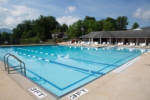 Una piscina al aire libre de temporada, sombrillas