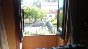 A room with a view of a courtyard, a bench, and a fountain. - Hotel Casa El Zaguan (Vilaflor)