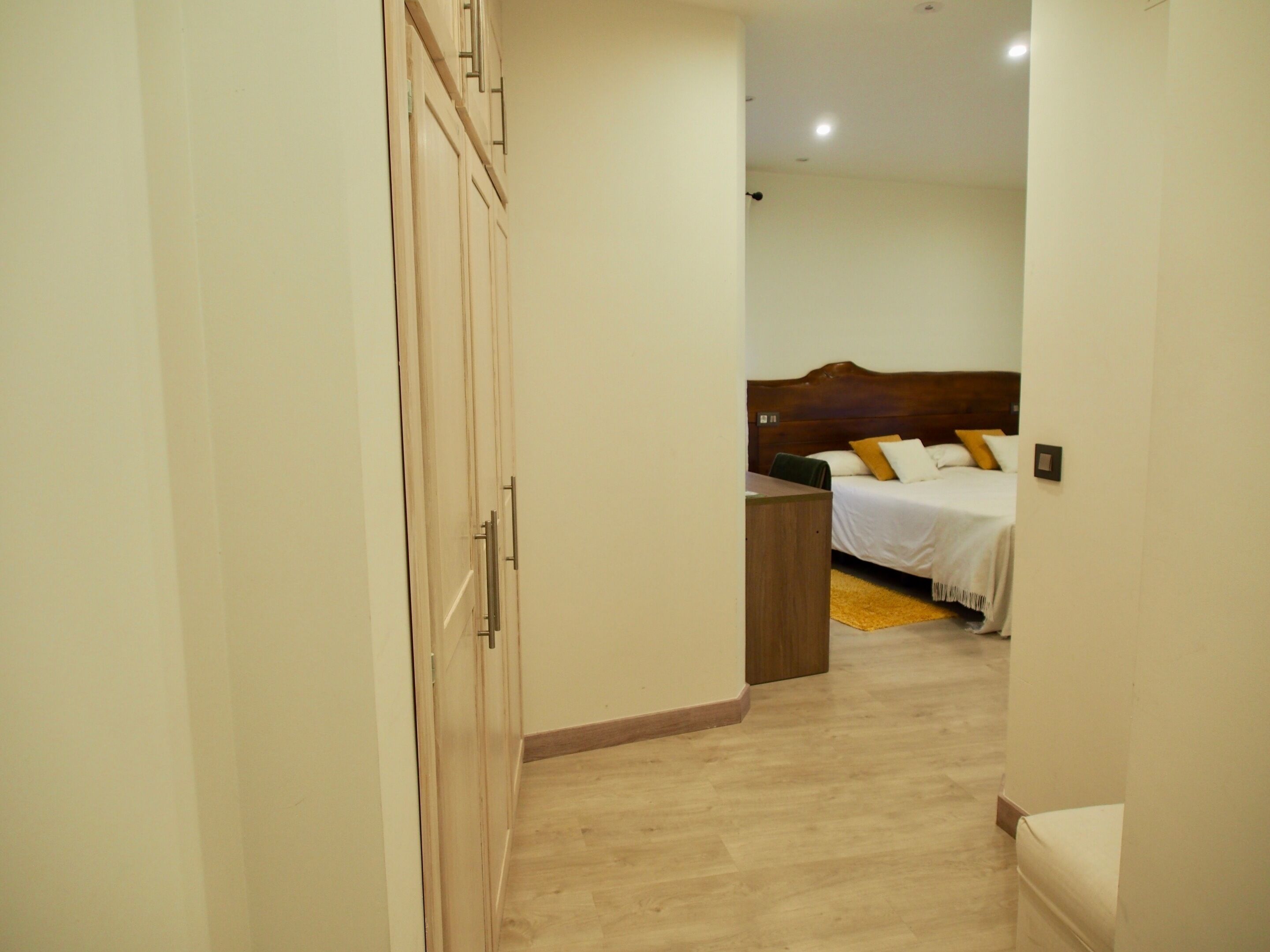 Un dormitorio con una cama de madera, una mesita de noche y un armario.