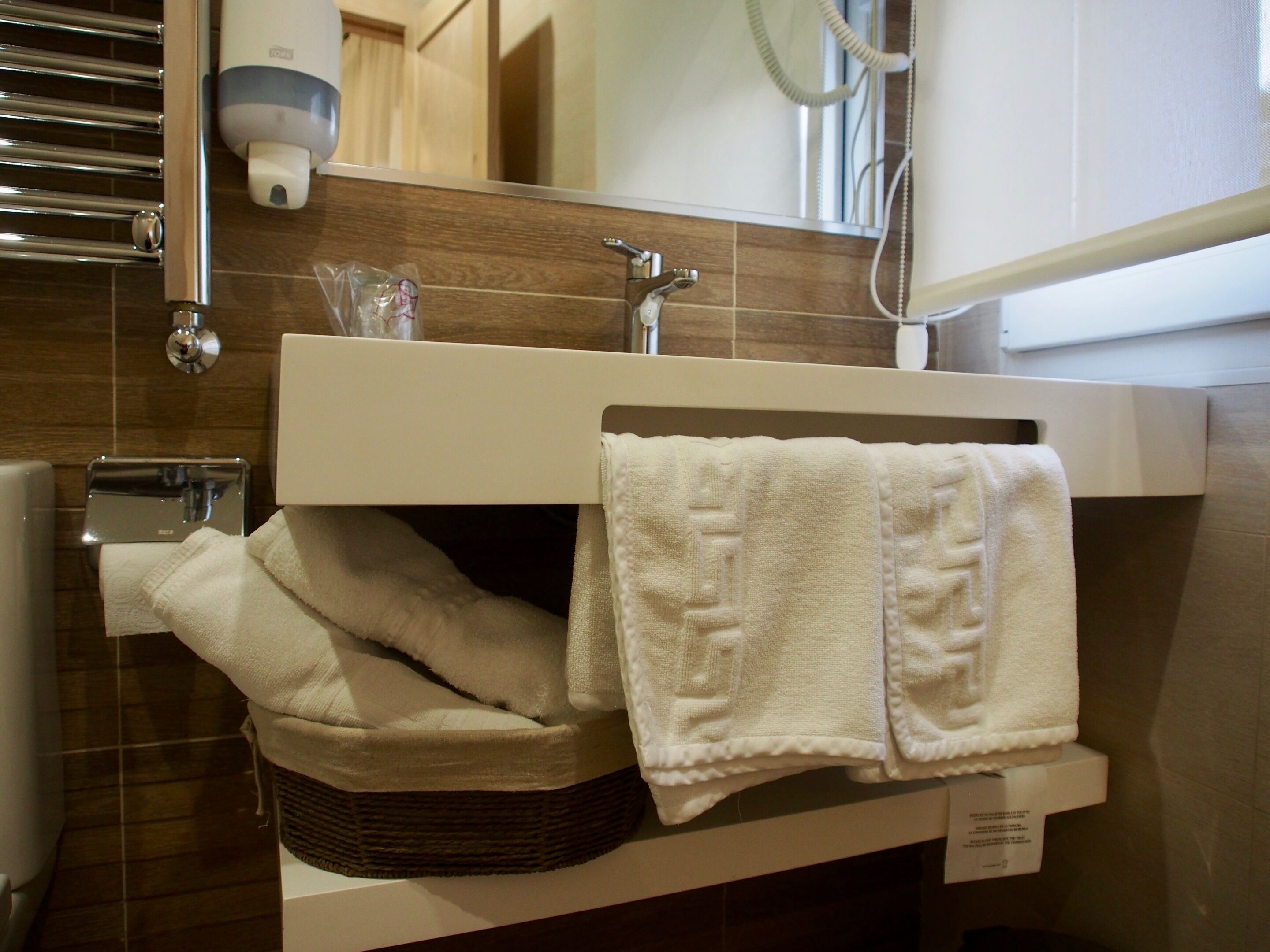 A bathroom with a sink, towel rack, and a mirror.