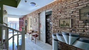 Un intérieur moderne avec un mur en briques, un escalier et un coin repas comprenant des chaises et une table.