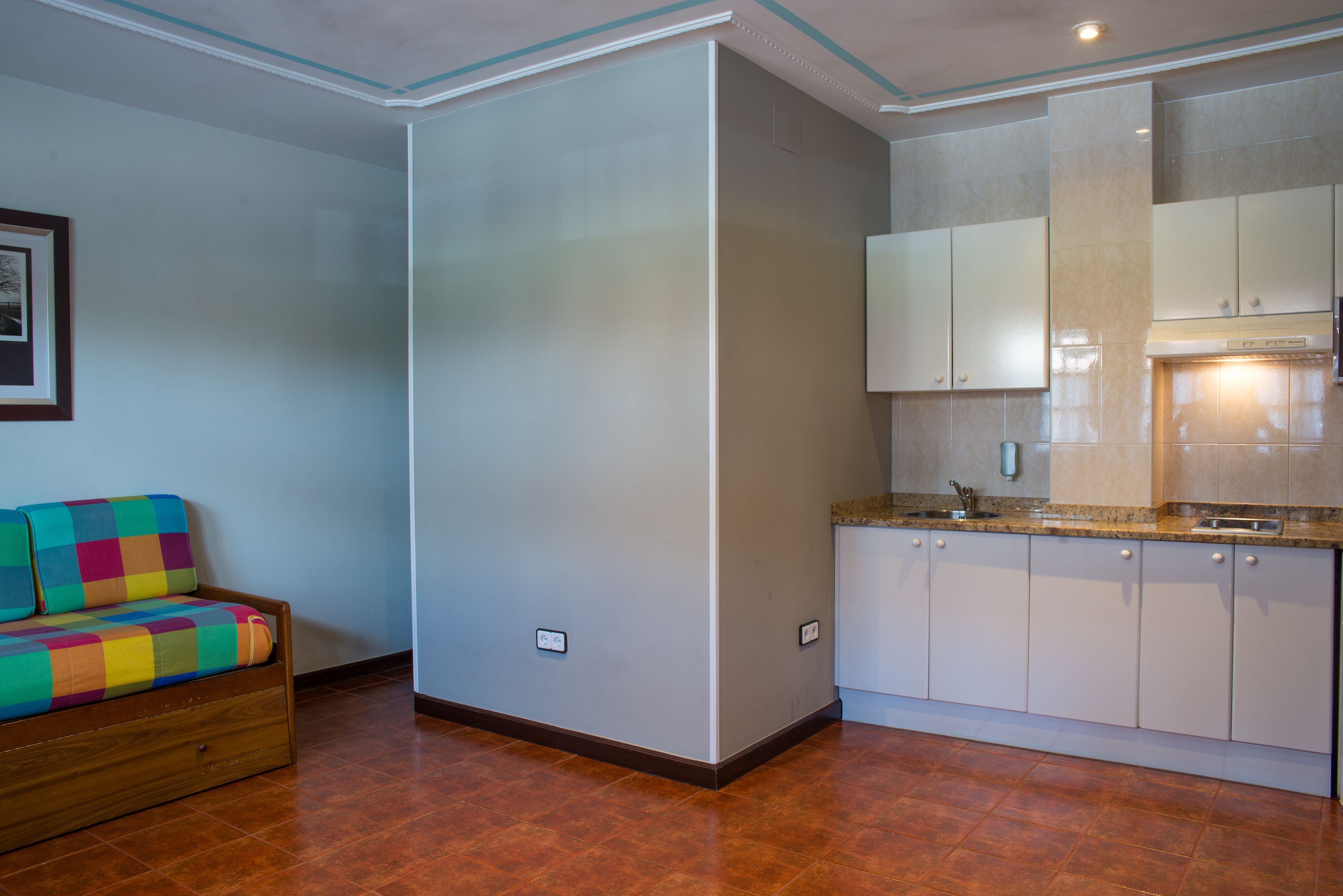 A modern kitchen with white cabinets, a countertop, and a built-in oven.