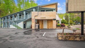 A two-story building with a wooden facade, a staircase, and a sign indicating a vacancy. - Country Town N'Suites (Gatlinburg)