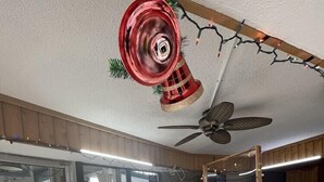 A reception area with a wooden counter, a ceiling fan, and a glass door entrance. - Country Town N'Suites (Gatlinburg)