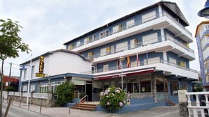 A multi-story hotel with a reception area, balconies, and a sign indicating it is a hotel named "Vivero". - Vivero Playa (Suances)