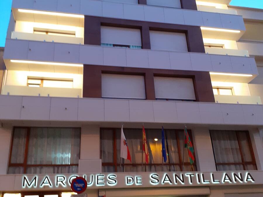 Un edificio moderno con el letrero "MARCJES DE SANTILLANA" en la entrada.