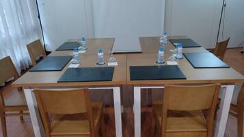 A conference room with a long table, chairs, water bottles, and name cards.