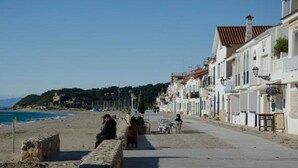 A coastal promenade with buildings, a beach, and a clear sky. - Hotel La Torreta (Altafulla)