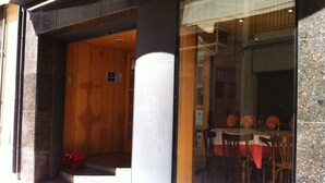 Un restaurante con interior de madera, entrada de vidrio y un letrero que indica ambiente familiar.
