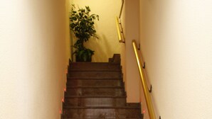 Una escalera de madera con barandilla que sube a un piso superior.