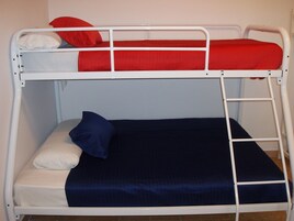 Una cama litera con dos niveles, cada uno con almohadas y un colchón.