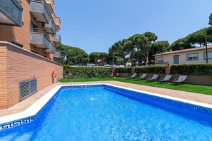 Una piscina al aire libre de temporada, sombrillas