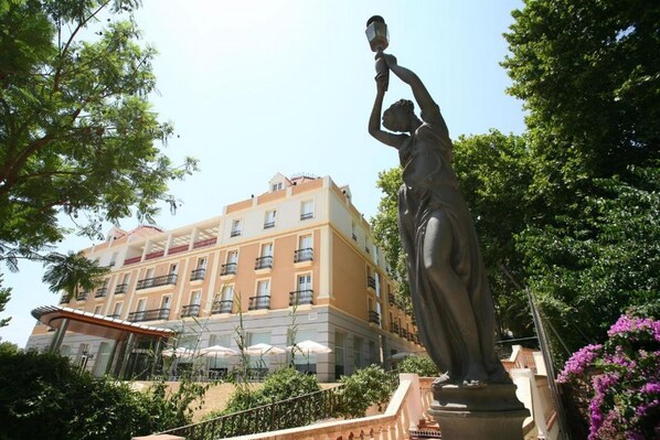 Eine Statue in einem Innenhof, im Hintergrund ein Gebäude.