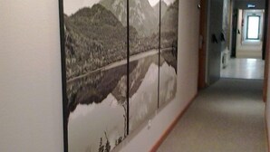 A corridor with a large wall mural of a mountainous landscape and a lake. - El Salugral Termal Resort (Hervas)