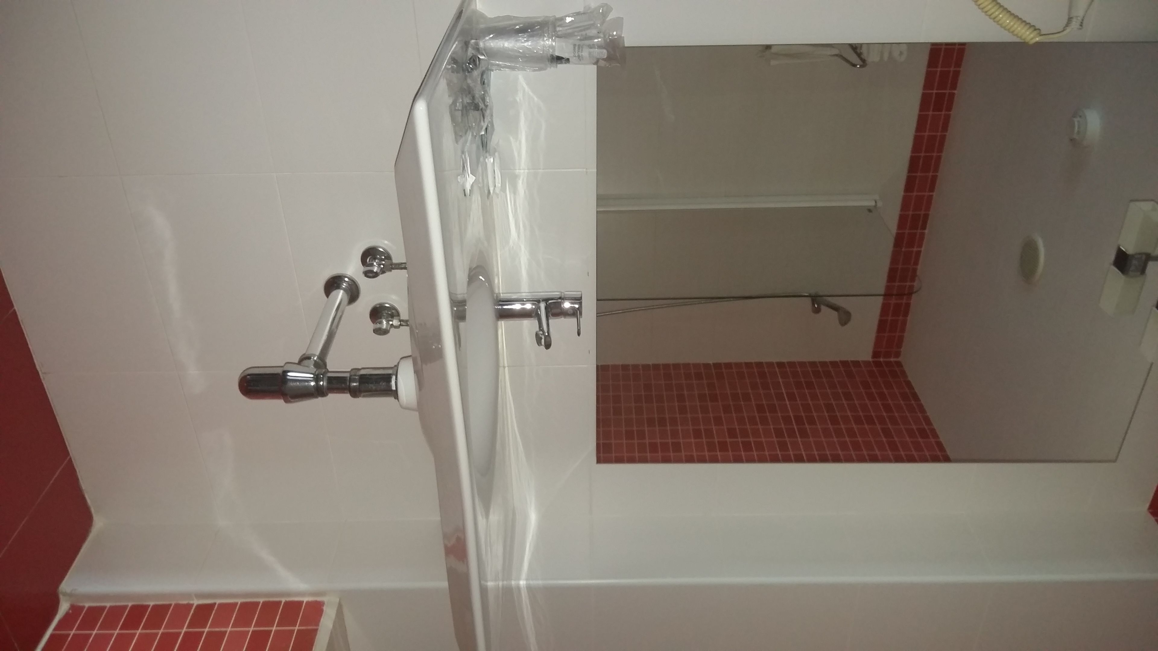 Un baño con bañera, ducha y espejo.