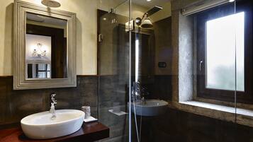 Une salle de bain moderne avec un grand miroir, un lavabo, une douche et une fenêtre.