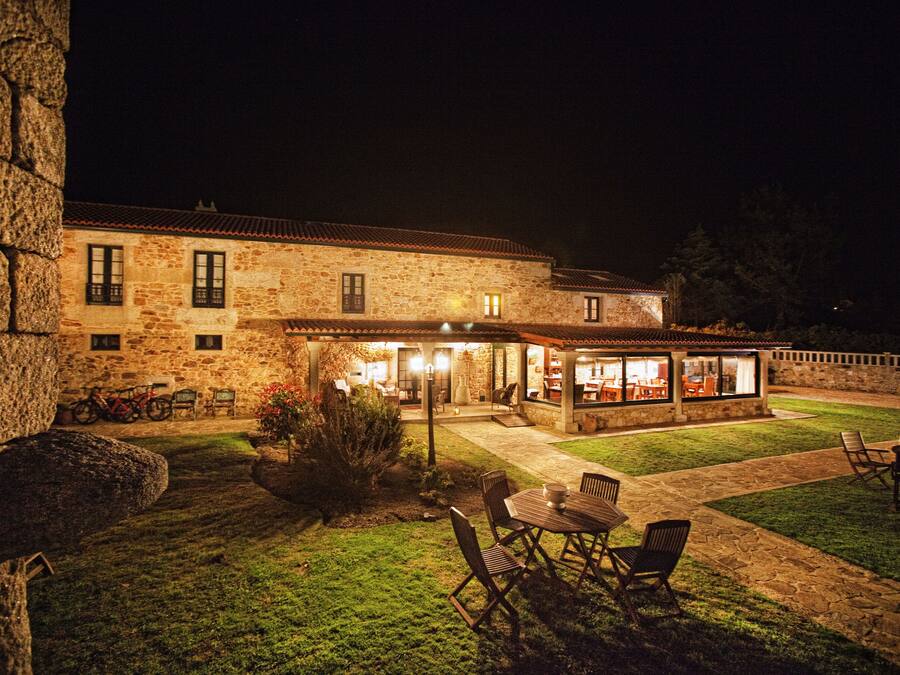 A stone building with a patio area featuring outdoor seating and a bar.