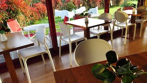 Ein Restaurant mit Außenbereich, weißen Stühlen und Tischen.