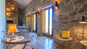 A cozy interior with stone walls, wooden furniture, and warm lighting. - Os Lambráns (Padron)